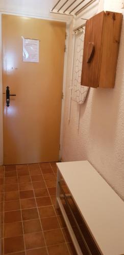 une pièce avec une porte, une armoire et un sol carrelé dans l'établissement Studio Aussois chaleureux, à Aussois