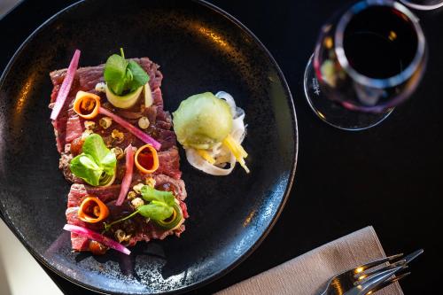 a plate of food on a table with a glass of wine at Hôtel Spa Restaurant Villa Castellane in Gréoux-les-Bains
