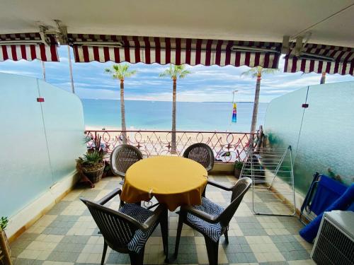 une table et des chaises sur un balcon avec vue sur l'océan dans l'établissement Constellation, à Juan-les-Pins