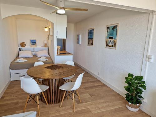 une pièce avec une table, des chaises et un lit dans l'établissement Virage au sud, au Barcarès