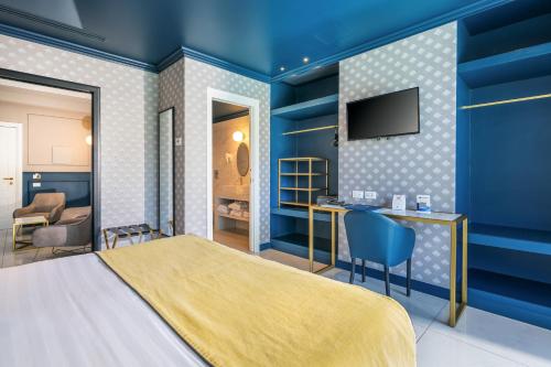 a bedroom with blue walls and a bed and a desk at Hotel Mary in Vico Equense