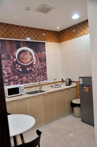 a kitchen with a sink and a painting on the wall at شقق المكان الراقي للشقق المخدمة in Riyadh