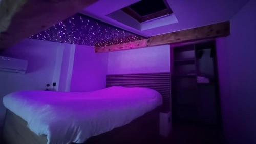 Cette chambre violette comprend un lit et un plafond. dans l'établissement Lou K-sea den, le terrier de la mer, à Cassis