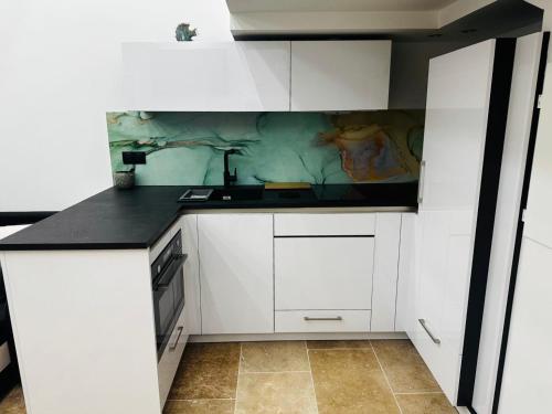 une cuisine avec des armoires blanches et un comptoir dans l'établissement Lou K-sea den, le terrier de la mer, à Cassis