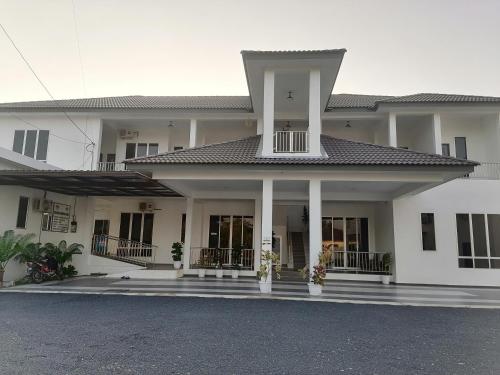 a large white house with a lot of windows at Lembah Saerah Resort in Kangar