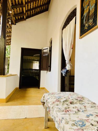 ein Schlafzimmer mit einem Bett in einem Zimmer mit einem Eingang in der Unterkunft Heritage Home in Kosgoda
