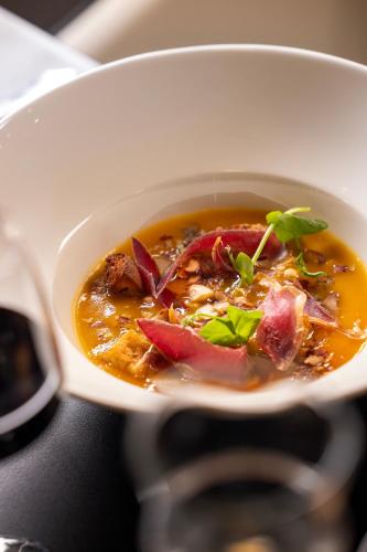 a white bowl of soup with meat and vegetables at Hôtel Spa Restaurant Villa Castellane in Gréoux-les-Bains