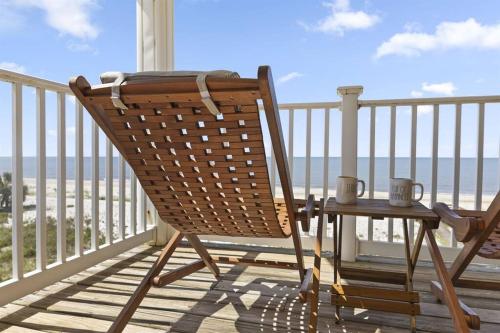 a rocking chair sitting on a porch with a table at Sun&Fun - Oceanfront, Quiet beach, Arcade games in Indian Pass