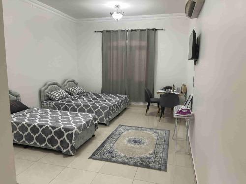 a bedroom with two beds and a table and a tableablish at Hostel Maral in Mawāliḩ