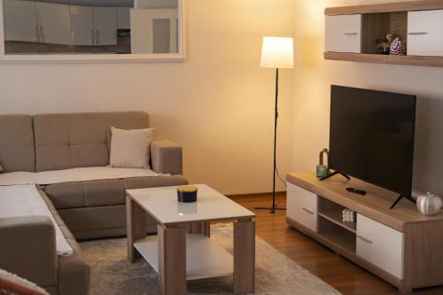 a living room with a couch and a flat screen tv at Apartman Dream in Livno