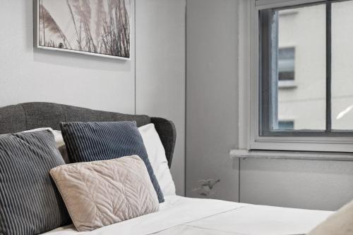 a bed with two pillows sitting next to a window at Standard Triple Room - Luxe Spot - Next to Central - Shared Bathroom in Sydney