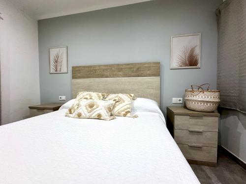 a bedroom with a large white bed with two night stands at Apartamento en primera linea con vistas al mar - VistaMar Blanes in Blanes