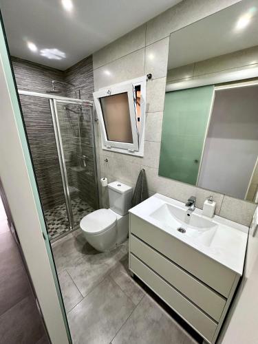 a bathroom with a toilet and a sink and a shower at Apartamento en primera linea con vistas al mar - VistaMar Blanes in Blanes