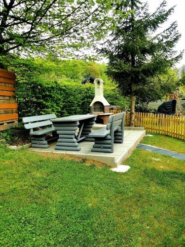 a picnic table and benches with a fountain in a yard at Ferienwohnung Waldbröl in Waldbröl