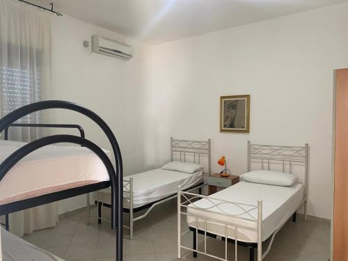 a room with three bunk beds and a window at Torre Lapillo in Torre Lapillo