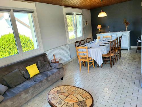 un salon avec une table et un canapé dans l'établissement Maison de bord de mer Alizée, à Saint-Germain-sur-Ay