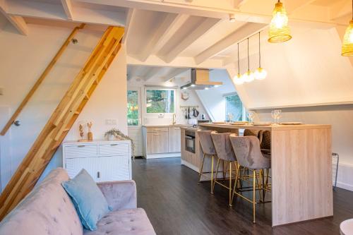 a kitchen and living room with a couch and a table at Chalet Lupin in Durbuy