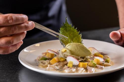 a person eating a plate of food with a spoon at Hôtel Spa Restaurant Villa Castellane in Gréoux-les-Bains