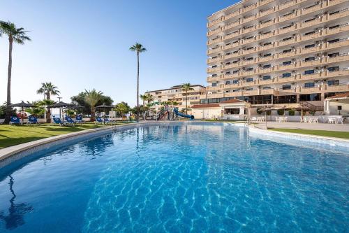 a large swimming pool in front of a large building at Hotel Playas de Torrevieja in Torrevieja
