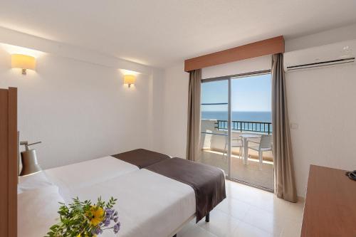 a bedroom with a bed and a view of the ocean at Hotel Playas de Torrevieja in Torrevieja