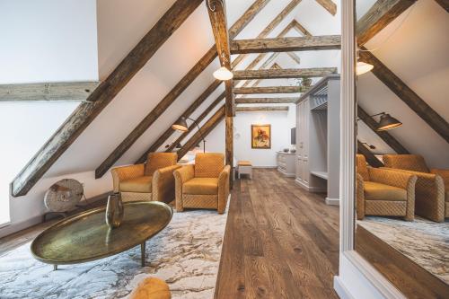 an attic living room with a table and chairs at Apartmány Šupina in Třeboň