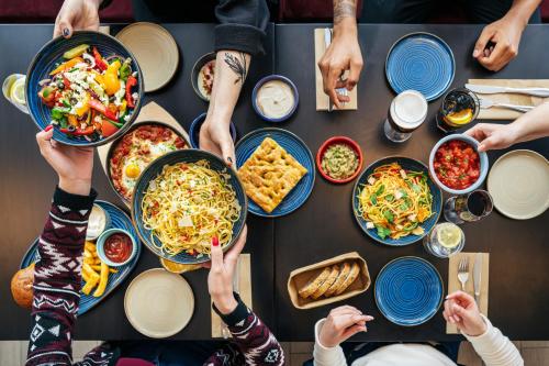 a group of people sitting around a table with food at Hotel Duo in Prague