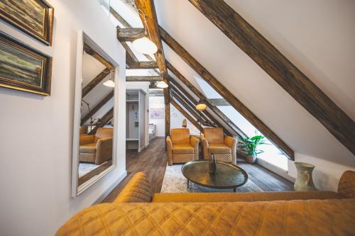 an attic living room with a couch and chairs at Apartmány Šupina in Třeboň