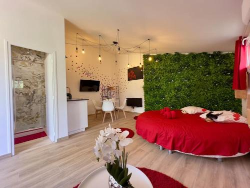 a bedroom with a red bed and a green wall at Duplex jacuzzi et table massage in LʼEscarène
