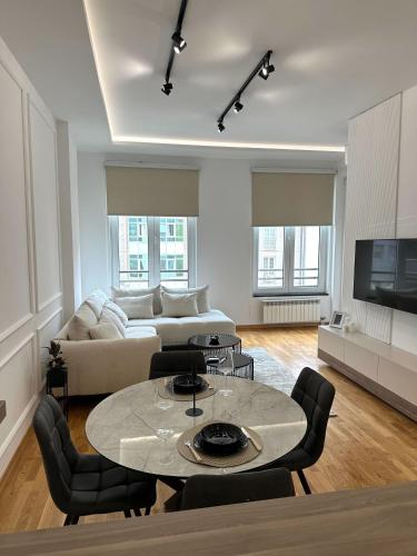 a living room with a table and a couch at LU Apartment in Novi Sad
