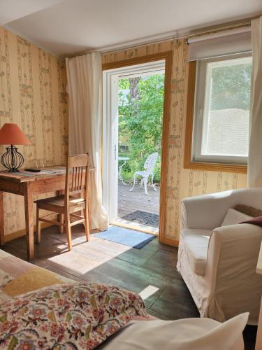 a living room with a desk and a couch and a window at Taulun Kartano in Kankainen