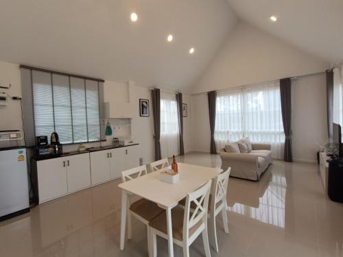a kitchen and living room with a white table and chairs at ร็อคกี้ พูลวิลล่า เขาใหญ่ Rocky Pool Villa Khaoyai in Pong Talong