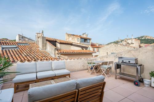 a patio with chairs and a grill on a roof at Chez Fleur par Dodo à Cassis in Cassis