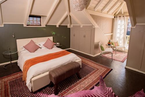 a bedroom with a large bed with pink pillows at Villa Margherita in Swakopmund