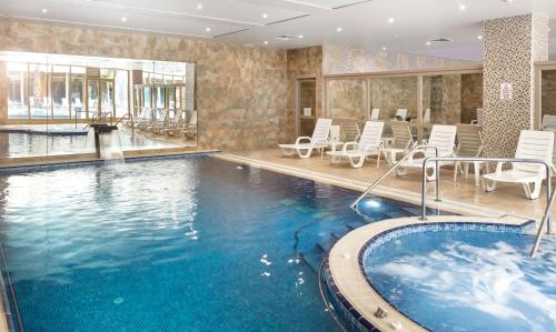 a large swimming pool with chairs and a large tub at İstanbul Medikal Termal in Tuzla