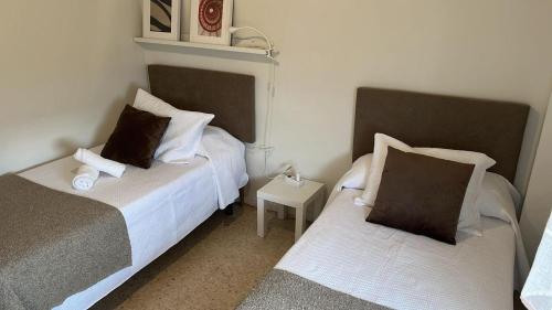 a bedroom with two beds and a small table at Cozy apartment next to center in Seville