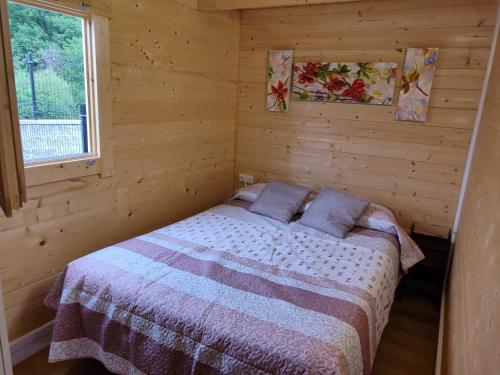 a bedroom with a bed in a wooden cabin at BUNGALOWS MARTINA in Coó