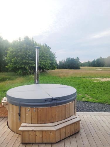 a hot tub on a deck with a view of a field at Vilanovka - domki z balią in Wilanowo