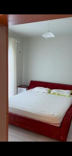 Una cama grande en un dormitorio con un marco rojo. en Lungomare, en Vlorë
