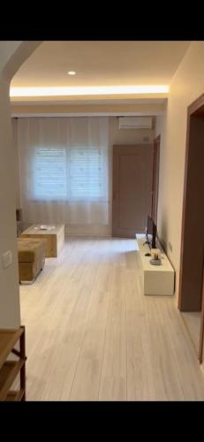 Una gran habitación vacía con suelo de madera. en Lungomare, en Vlorë