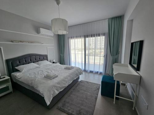 a bedroom with a bed and a desk and window at Pompeius Beachside Retreat 2-Bedroom Apartment g-7 in Perivolia tou Trikomou