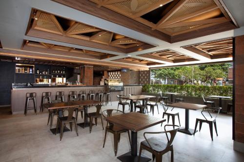 a restaurant with tables and chairs and a bar at Platinum Hotel Jimbaran Beach Bali in Jimbaran
