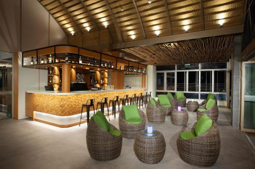 a lobby with green chairs and a bar at Platinum Hotel Jimbaran Beach Bali in Jimbaran