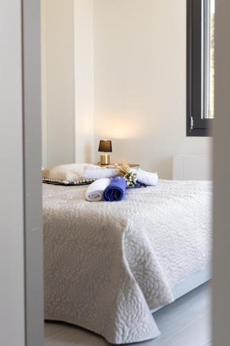 a bed with white sheets and a lamp on it at Lampetos Houses Molyvos in Mithymna