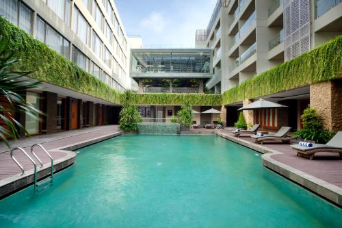 a swimming pool in the middle of a building at Platinum Hotel Jimbaran Beach Bali in Jimbaran