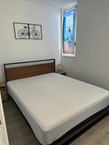 - un lit dans une chambre avec un vélo sur le mur dans l'établissement Le Marin, à Saint-Cyprien