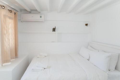 a white room with two beds and a window at Manto Sunset Loft in Mýkonos City