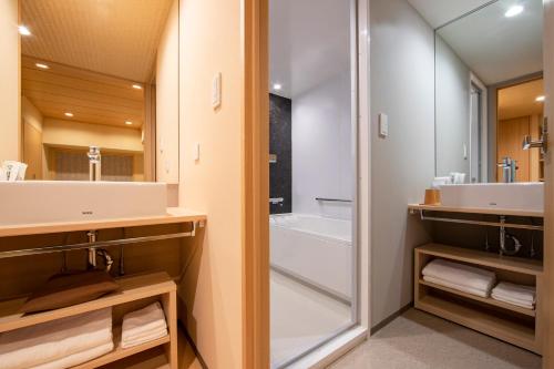 a bathroom with a tub and a sink and a shower at karaksa hotel TOKYO STATION in Tokyo