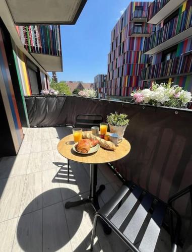 une table avec de la nourriture et des boissons sur un balcon dans l'établissement Charmant appartement avec balcon proche de Paris, à La Courneuve