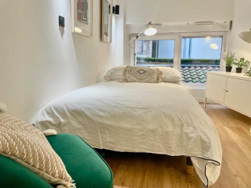une chambre blanche avec un lit et une fenêtre dans l'établissement COSY DUPLEX au coeur de lYON 6, à Lyon