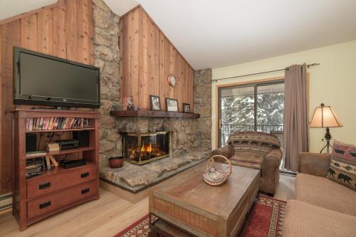a living room with a fireplace and a tv at Beaver Village Unit #0232R in Winter Park